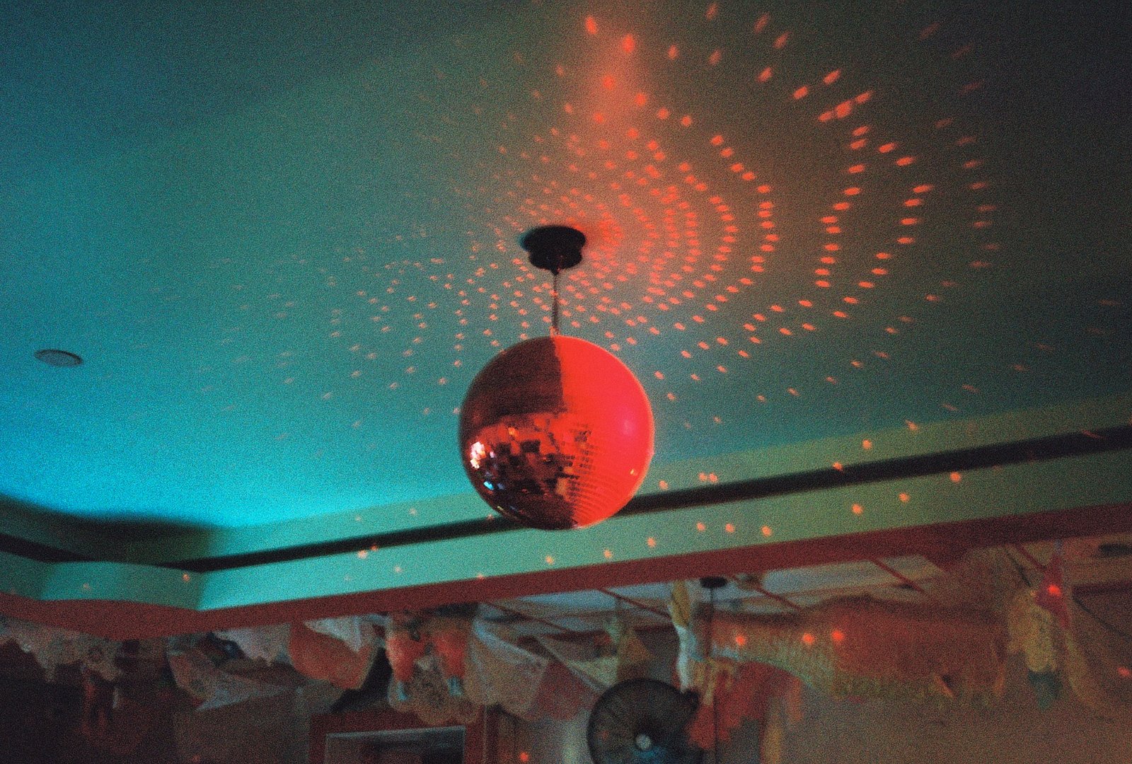 Red disco ball reflecting light patterns on a ceiling in Austin, Texas
